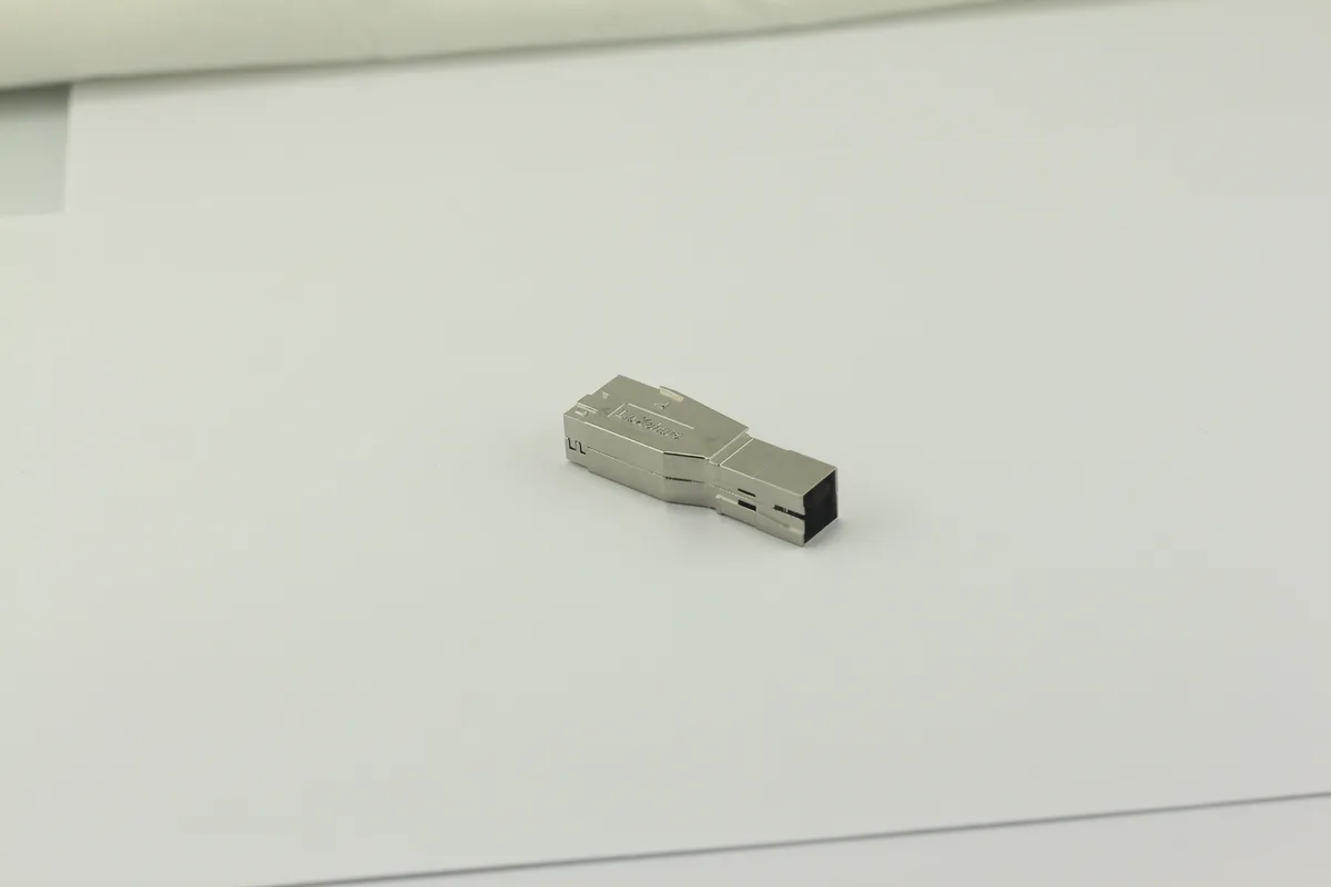 Close-up of a screw terminal block with stripped wires inserted and a screwdriver tightening the screw clamp